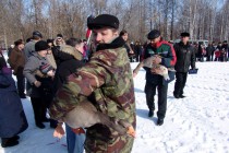 Ассистенты уносят гуся победителя, следом несут проигравшего гуся