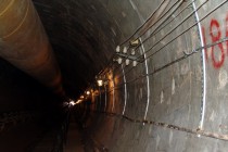 Строящийся тоннель освещают тусклые лампочки