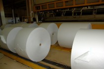 Готовый рулон газетный бумаги разрезается на несколько частей