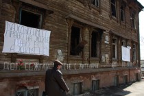 На внешней стороне сгоревшего дома жители разместили плакаты