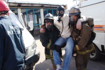 Спасатели эвакуируют из здания условного пострадавшего