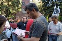 Борис Немцов получает из рук организаторов плакат с лозунгом