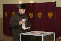 Житель Нижнего Новгорода опускает бюллетень на избирательном участке 1663 в день выборов депутатов Государственной Думы РФ шестого созыва