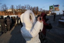 Случайные прохожие фотографируют на память подготовку к митингу