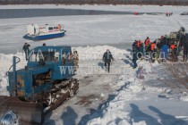 Спасатели при помощи трактора и тросов затаскивают вертолет волоком для погрузки