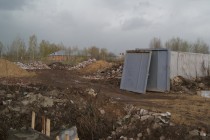 Также за забором – кучи строительного мусора и щебня