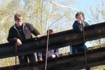 Рыбаки при помощи зыбки ловят рыбу около плотины