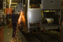 Работник завода обрабатывает корпус автобуса в сварочном цехе Павловского автобусного завода