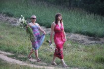 Девушки заготавливают цветы для плетения венков