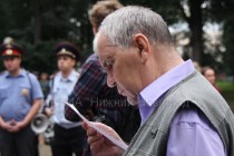 Прохожий изучает листовку, розданную участниками акции