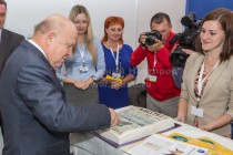 Губернатор Нижегородской области Валерий Шанцев режет торт на стенде газеты Известия