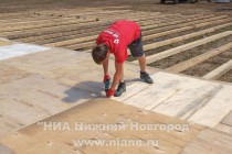 Рабочие надежно закрепляют покрытие для танцпола