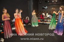 Участницы конкурса красоты готовятся ко второму выходу - дефиле в вечерних платьях с узорами в стиле городецкой и хохломской росписи из новой коллекции Иволга