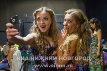 Участницы конкурса красоты готовятся ко второму выходу - дефиле в вечерних платьях с узорами в стиле городецкой и хохломской росписи из новой коллекции Иволга