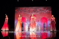 Дефиле участниц конкурса в вечерних платьях с узорами в стиле городецкой и хохломской росписи из новой коллекции Иволга