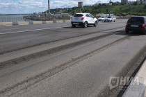 Автотранспорт движется с замедлением скорости из-за срезанного асфальта на полосах дороги