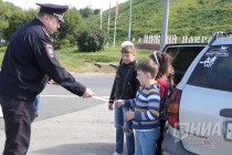 Начальник пресс-службы Управления ГИБДД НО Игорь Михайлушкин дарит детям светоотражающие ленты