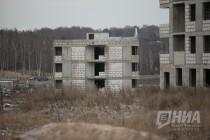 Рядом с малоэтажными домами стоит скелет высотного здания